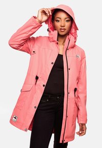 Parka impermeabile rosa con cappuccio, dotata di chiusura con zip e bottoni, tasche laterali e lacci per l'aggiustabilità.