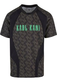 Trumpai rankovėmis sportinė marškinėliai su žalia "KARL KANI" grafika, juodomis šoninėmis juostomis ir viso paviršiaus tamsiu raštuotu tekstūru.