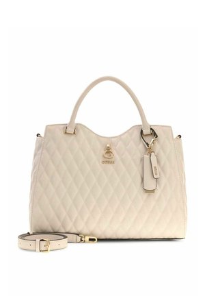 Sac à main beige matelassé avec doubles poignées, logo Guess doré, étiquette attachée et bandoulière ajustable assortie avec boucle dorée.