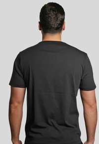 T-shirt nero a maniche corte realizzato in cotone, con un classico colletto tondo e una texture liscia e uniforme. Vista posteriore mostrata.