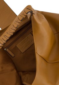 Wn�ętrze torebki wykonanej ze skóry w odcieniu tan, z zamykaną na zamek kieszonką i metką ze skóry z logo. Gładka tekstura z widocznymi akcentami przyszycia. Przestronny design.