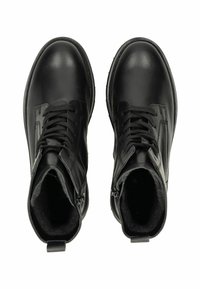 Une paire de bottes en cuir noir à lacets avec des zips latéraux et un intérieur rembourré, vue de dessus sur un fond blanc.