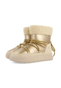 Botas doradas y beige con un cuello de color crema esponjoso, aseguradas con cordones beige y una suela gruesa de color crema. Acabado de material suave.