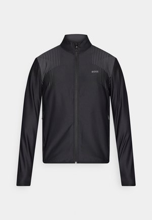 Zwarte sportieve jas met ritssluiting, voorzien van een gestructureerd patroon op de schouders en subtiele branding op de borst.