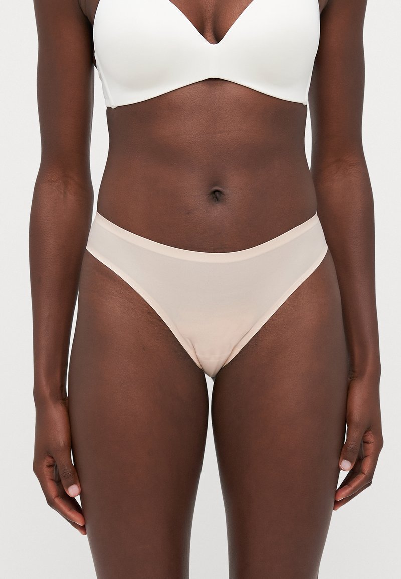 Nude-colored seamless bikini underwear with a smooth texture, thin elastic waistband, and minimalistic design.