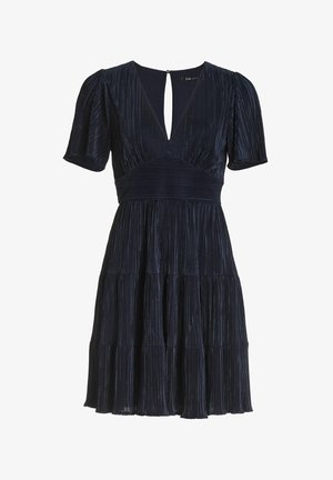 Marineblauwe geplooide jurk met korte mouwen, diepe V-hals, aansluitend lijfje en gelaagde rok. Heeft een sleutelgat op de rug en een gestructureerde stof.