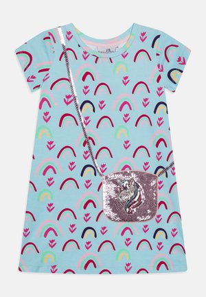 Blaues, kurzärmliges Kleid mit einem wiederholten Muster aus Regenbögen und Blumen. Enthält eine glitzernde pinkfarbene Einhorn-Handtasche mit silberner Kettenriemen.