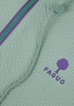 Lichtgroene gestructureerde stof met paarskleurige ritssluiting en logo met een boom en de tekst "FAGUO", plus een groen trekkoord met een plastic stopper.
