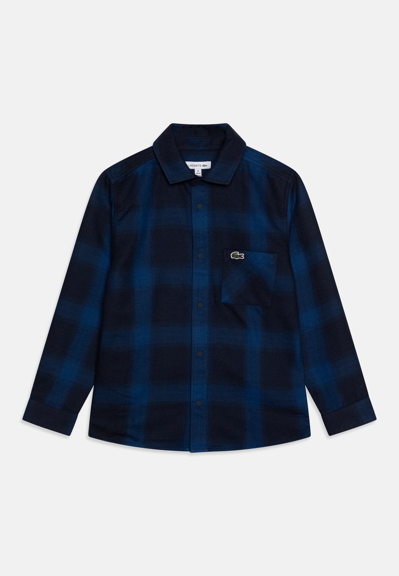 Navyblauwe geruite knoopshirt van flanel, met een borstzak en een klein groen krokodillenlogo op de zak.