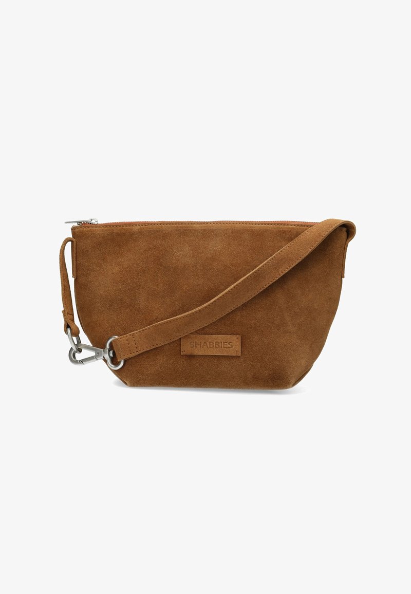 Pochette en daim marron avec fermeture éclair, bandoulière ajustable, quincaillerie argentée et petite étiquette en cuir. Texture lisse avec un design simple.
