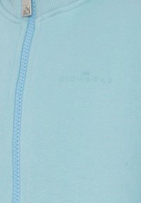 Jasnoniebieska bluza zapinana na zamek z prążkowanej tkaniny, z gładkim zamkiem błyskawicznym i wytłoczonym napisem "JOHN RICHMOND."