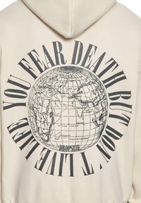 Felpa con cappuccio color crema con una grafica di un globo e il testo nero "HAI PAURA DELLA MORTE MA NON MENTIRE ALLA VITA." Texture morbida e design casual.