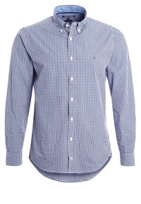 Camisa de manga larga con botones en patrón de cuadro vichy azul marino y blanco. Presenta un cuello suave y un detalle de logotipo en el pecho izquierdo.
