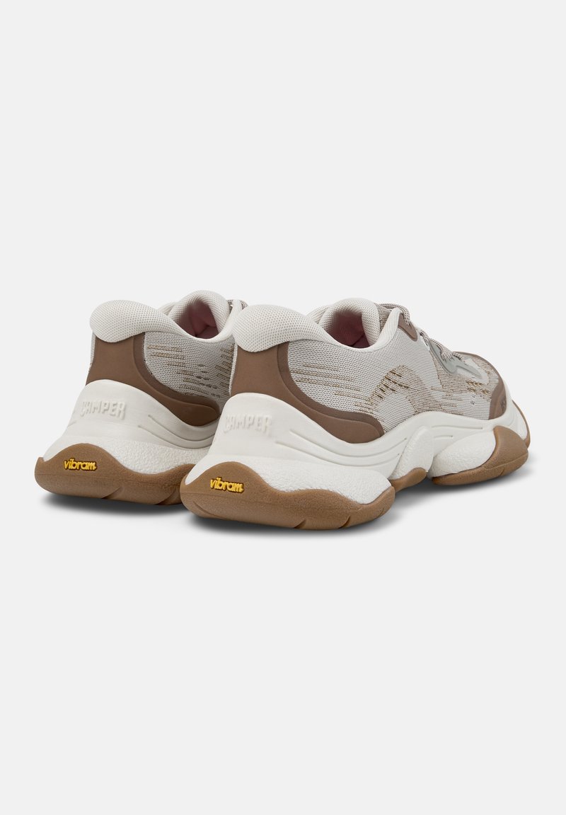 Tan og beige sneakers med en struktureret mesh-overdel, gummisål og et Vibram-brandingaccent på ydersålen. Bemærkelsesværdig polstret krave.