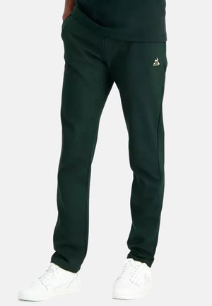Pantalons de survêtement verts avec une coupe décontractée, dotés de poches latérales, d'une taille élastique et d'un petit logo doré sur la cuisse gauche.