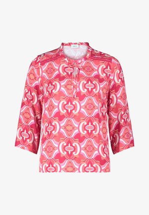 Bluzka w wzory z okrągłym dekoltem i rękawami o długości trzech ćwiartek. Dominujące kolory to różowy i koralowy w geometryczne wzory. Miękka tkanina.