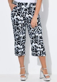 Černobílé vzorované zkrácené kalhoty s květinovým motivem, mají široký pas a boční kapsy. V kombinaci se stříbrnými platformovými podpatky.