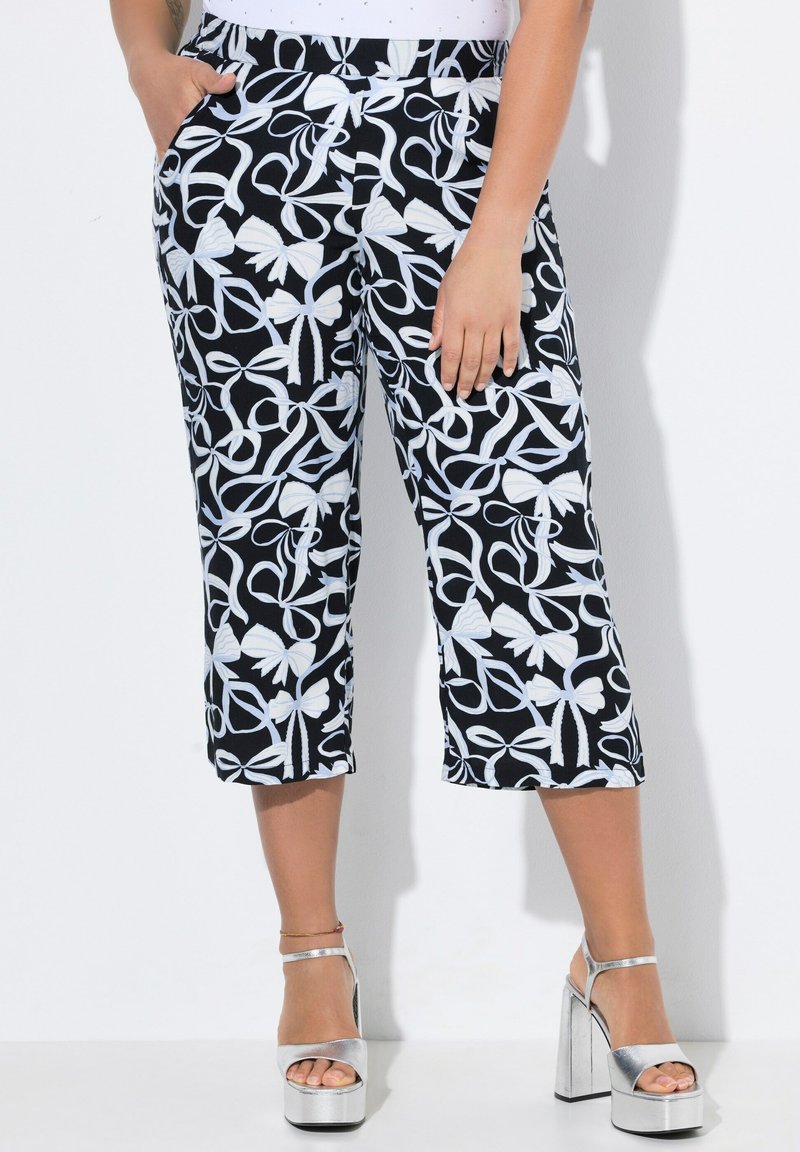 Černobílé vzorované zkrácené kalhoty s květinovým motivem, mají široký pas a boční kapsy. V kombinaci se stříbrnými platformovými podpatky.
