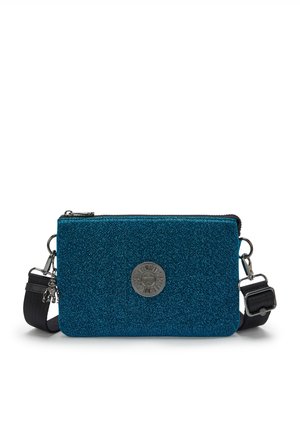 Borsa a tracolla blu con glitter, dotata di un emblema metallico circolare, chiusura a zip e tracolla regolabile. Presenta una superficie testurizzata e un design rettangolare elegante.