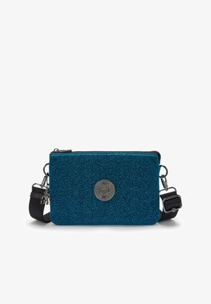 Borsa a tracolla blu con glitter, dotata di un emblema metallico circolare, chiusura a zip e tracolla regolabile. Presenta una superficie testurizzata e un design rettangolare elegante.