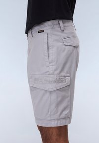 Lys grå cargo shorts lavet af vævet stof. Har en lomme med præglogo, sidelommer og en standard talje.