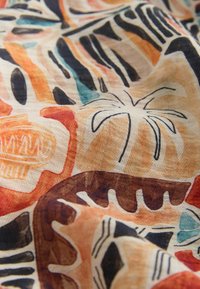 Material cu un model abstract ce include forme în portocaliu, maro, negru și albastru, printre care conturul unui palmier și designuri geometrice.