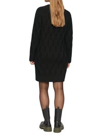 Schwarzes Strickkleid mit strukturiertem Muster und langen Ärmeln, kombiniert mit knielangen schwarzen und grünen Stiefeln.