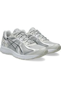 Paire de chaussures de course ASICS argentées et blanches avec empeigne en mesh, design à lacets et semelles rembourrées, légèrement inclinées vers la droite.