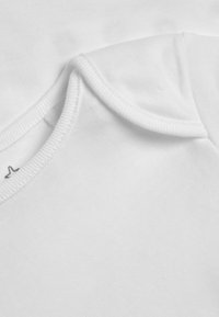 T-shirt en coton blanc avec un col rond côtelé, texture lisse et une légère courbure au niveau de la couture de l'épaule. Pas de motifs ni de logos visibles.
