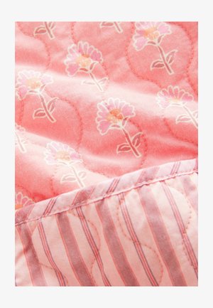 Pufasti ružičasti materijal s cvjetnim uzorcima u svijetlo ružičastoj i narančastoj boji. Stražnja strana ima ružičasto-bijeli prugasti dizajn. Meka tekstura.
