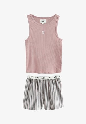 Ärmelloses, rosa, geripptes Tanktop mit „self.“-Logo kombiniert mit gestreiften Shorts mit weißem Bund, der mehrfach mit „self.“ bedruckt ist.