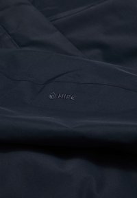 Tkanina tamnoplave boje sa glatkom teksturom; sadrži utisnuti logo "HIPE", koji ukazuje na vodootporna svojstva i moderni dizajn.