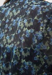 Blumenmusterstoff in Grüntönen, Blau und Schwarz mit feinen vertikalen Linien und Struktur. Leicht und fließendes Design.
