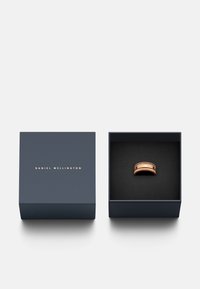 Rose gold ring with textured surface, set in a dark navy box with a black interior. Box features "DANIEL WELLINGTON" in gold lettering.