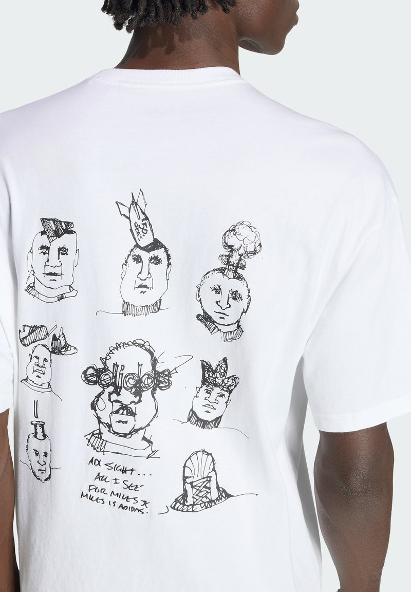 Ryggen af en hvid T-shirt med sorte abstrakte skitser af ansigter, et med teksten "ADIDAS" og håndskrevet tekst nedenunder.