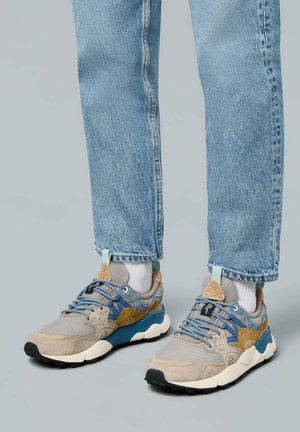 Hellgraue und blaue Sneakers aus Mesh und Wildleder, mit schwarzen Sohlen, beigen Akzenten und strukturierten Schnürsenkeln.