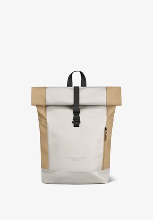 Rullikinnitusega beež ja helepruun seljakott musta pandla ja tõmbluku ning küljetaskutega, millel on "Gaston Luga Stockholm" bränd.