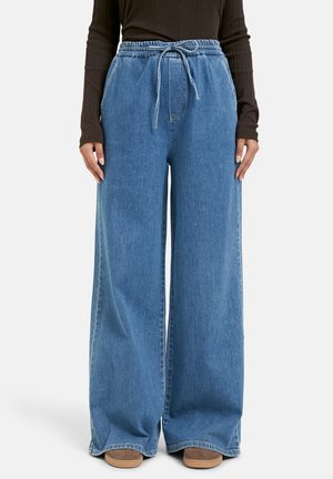 Wide-leg denim pants in light blue with an elastic waistband and drawstring. Fabric has a smooth texture and slight fade.