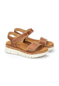 Sandalias de cuero marrón con costuras blancas, tiras ajustables, plantilla de corcho y suela de goma texturizada para mayor agarre. Diseño ligero y abierto.