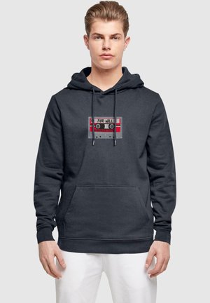 Dunkelgrauer Hoodie mit Grafik eines Kassettenspielers und roten Akzenten, "FÜR WILL" und dem Text "STRANGER THINGS". Mit vorderer Kängurutasche und Zugband.