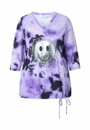 Lilla tie-dye top med V-hals, trekvartærmer, indsnævret bund og sølvfarvet smiley-grafik med teksten "POSITIV TENKNING."