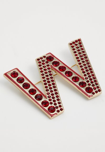Broche en forme de lettre "W" ornée de joyaux rouges, en métal doré et cristaux rouges facettés, présentant un design texturé avec des tailles de cristal variées.