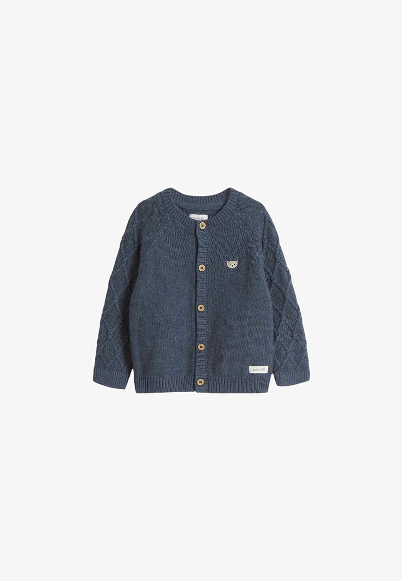 Sininen neulekortti, jossa on pyöreä kaula-aukko, hihoissa timanttikuvio, puunapit ja pieni eläinlogo rinnassa.