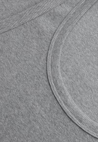 Szara bawełniana tkanina z prążkowaną strukturą i gładkim brzegiem kołnierza, o bezszwowym wykończeniu, podkreślająca miękkość i elastyczność.