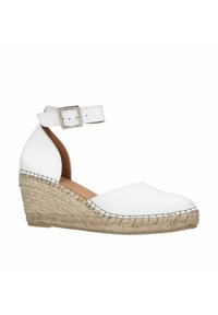Witte leren wedge espadrille met enkelband, voorzien van een gevlochten jute zool en gestikte details langs de basis voor extra textuur.