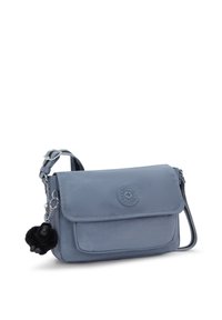 Piccola borsa a tracolla blu con patta, tasca frontale, tracolla regolabile e un portachiavi in peluche nero attaccato al lato.