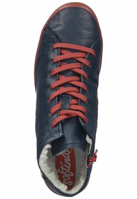Zapatilla de cuero en azul marino con cordones rojos, que presenta un zipper lateral, un forro interior suave y una suela de goma texturizada. Logotipo de la marca rojo visible en el interior.