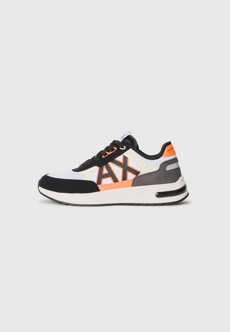 Zapatillas deportivas que combinan materiales en negro, blanco y gris, con un logotipo y detalles en naranja, y una suela acolchada para mayor comodidad.