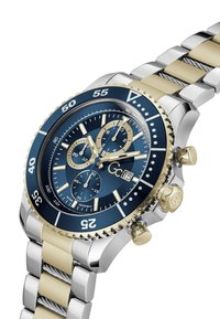 Chronograph watch with a blue dial, gold and silver stainless steel band, tachymetric bezel, and multiple sub-dials. Features a crown and pushers.
