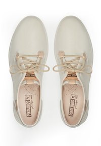 Zapatos de cuero beige claro con puntera redonda, diseño de cordones y acentos en color marrón claro; con un suave forro interior y el logo de la marca en la plantilla.
